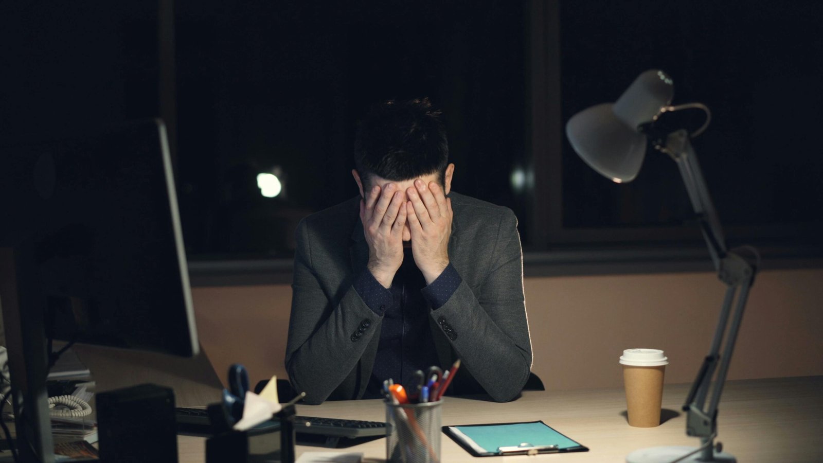 Man experiencing stress and overwhelm at work, illustrating signs of nervous system dysregulation and chronic stress