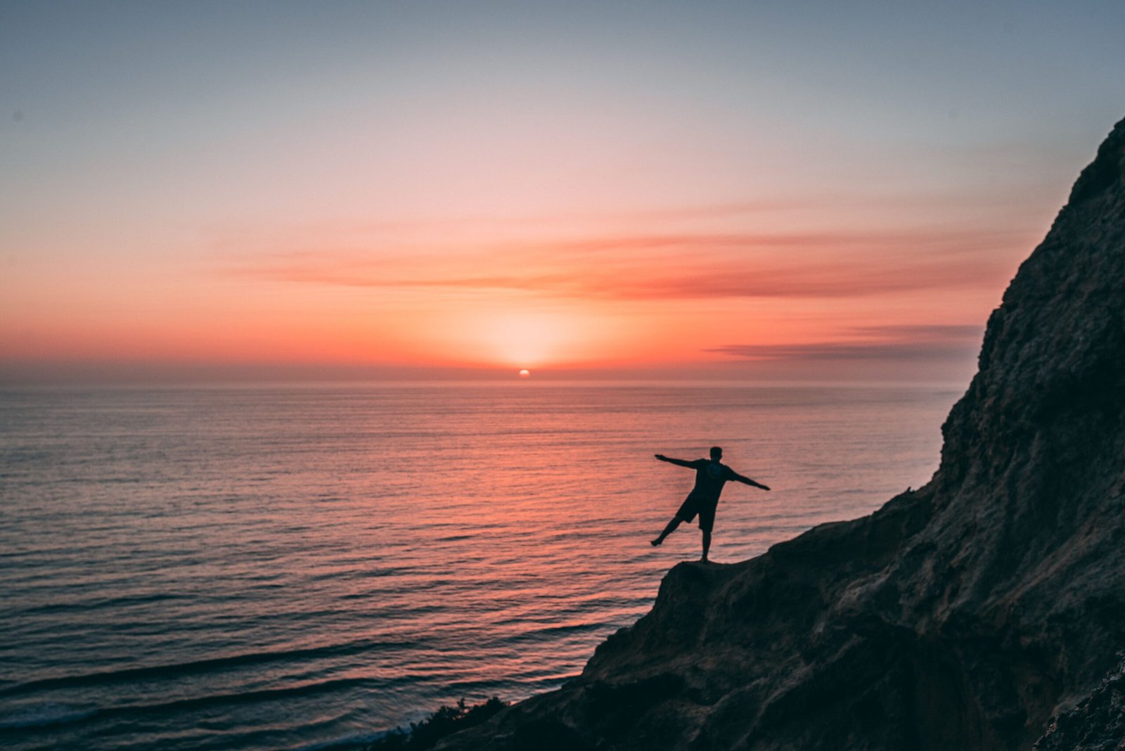 Man practicing balance training on one leg at sunset to improve stability and nervous system control.